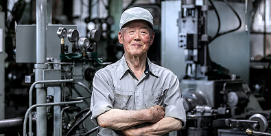 腕を組むスーツ姿の男性